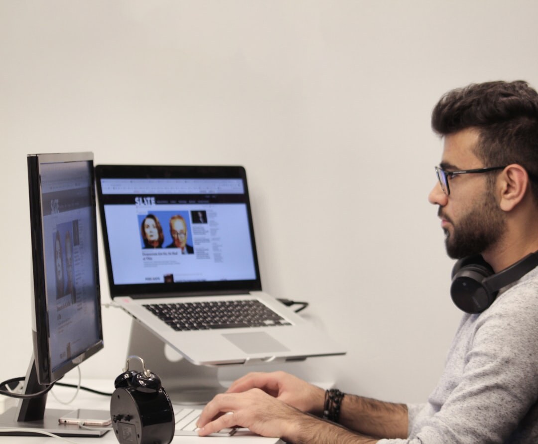 Professional working on a laptop in a modern newsroom office